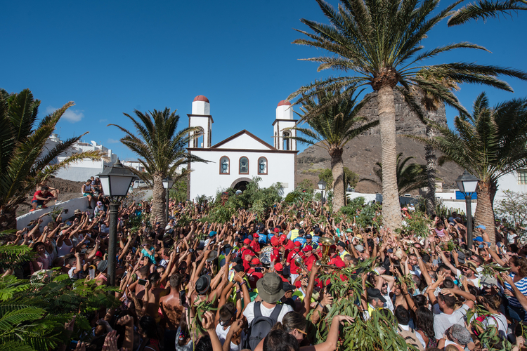 Weitläufige Sanddünen mit markanten Windrillen unter blauem Himmel mit leichten Wolken.
